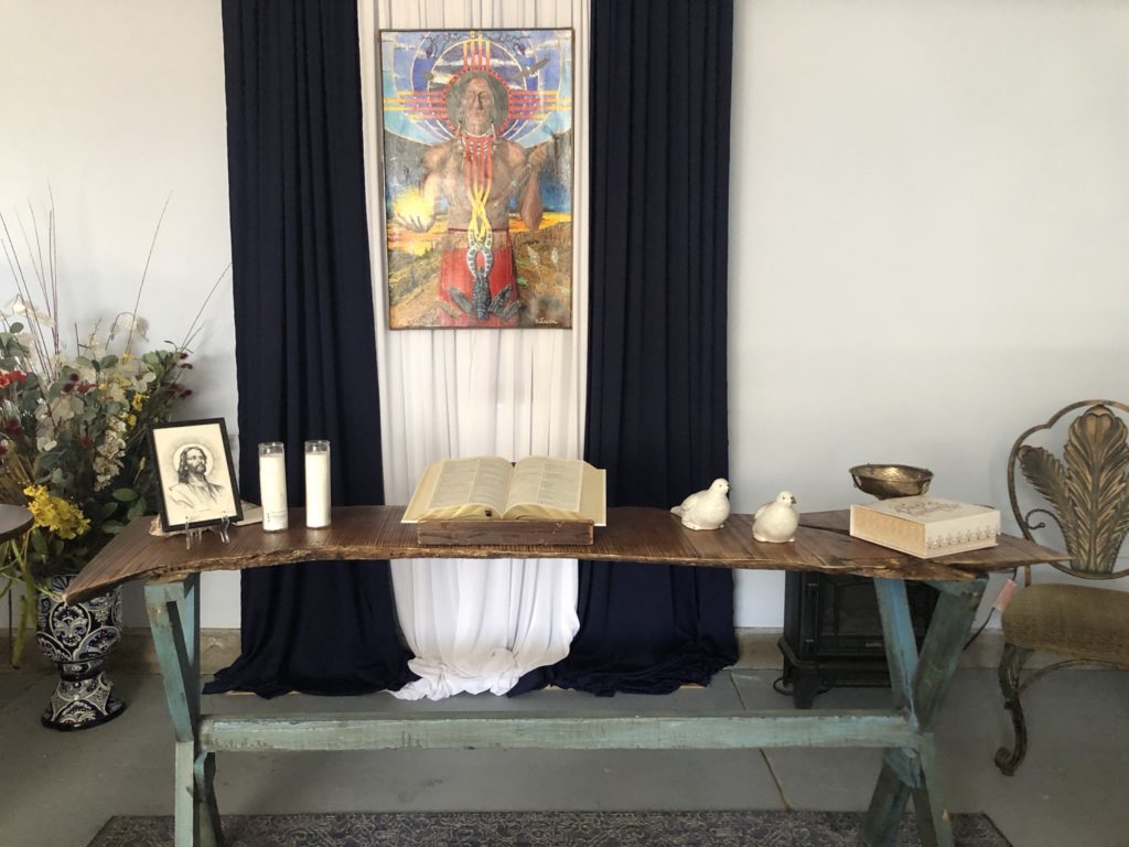 Peaceful New Church of the Southwest Desert sanctuary with our ironwood altar, the open Word, two doves, prayer candles, and “Jesus of the Southwest Desert” by church member, Dug Sitowski, who recently transitioned to the spiritual world